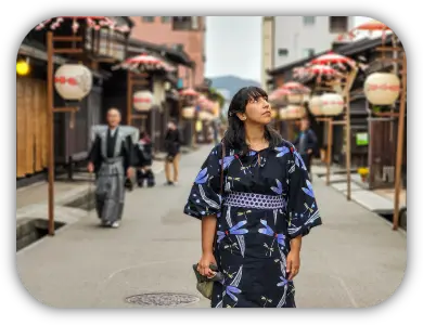 Viajante de yukata em uma rua de Takayama com construções tradicionais e lanternas