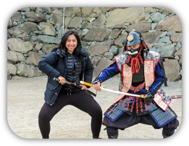 Viajante posando ao lado de uma pessoa vestida com armadura de samurai