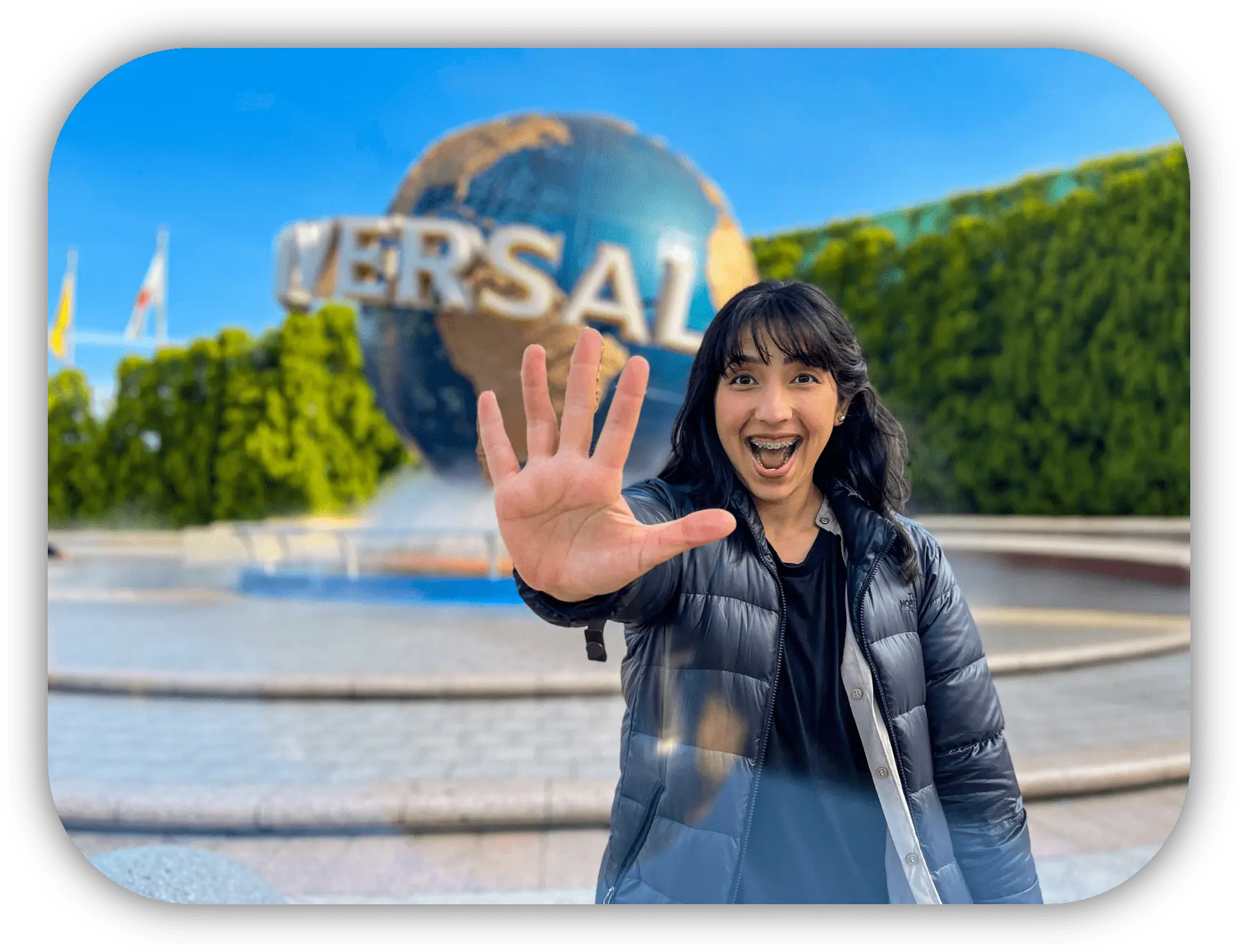 Viajante sorrindo diante do globo do Universal Studios Japan